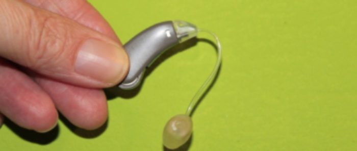 Man holding a hearing aid device